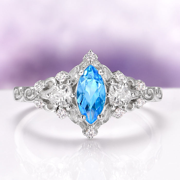 Elain Swiss Blue Topaz Leaf Engagement Ring in 14K White Gold by Aquamarise Gold, featuring a marquise-cut Swiss Blue Topaz center stone with sparkling diamond accents and intricate leaf-inspired details, part of Solid Gold Engagement Rings and November Birthstone collections.
