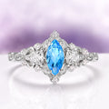 Elain Swiss Blue Topaz Leaf Engagement Ring in 14K White Gold by Aquamarise Gold, featuring a marquise-cut Swiss Blue Topaz center stone with sparkling diamond accents and intricate leaf-inspired details, part of Solid Gold Engagement Rings and November Birthstone collections.