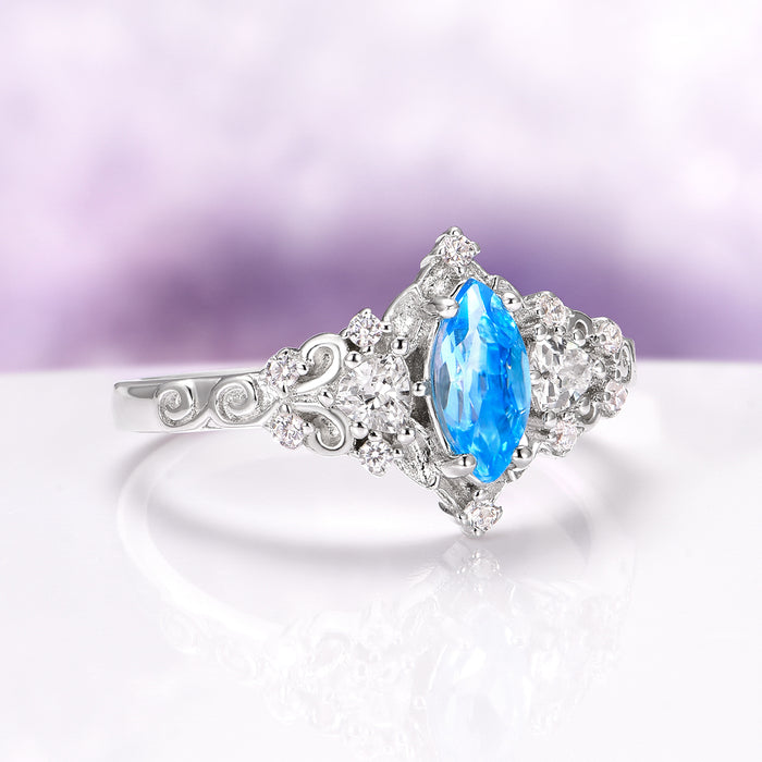 Elain Swiss Blue Topaz Leaf Engagement Ring in 14K White Gold by Aquamarise Gold, featuring a vibrant marquise-cut Swiss Blue Topaz center stone surrounded by sparkling diamond accents and delicate leaf-inspired detailing, from the Solid Gold Engagement Rings and November Birthstone collections.