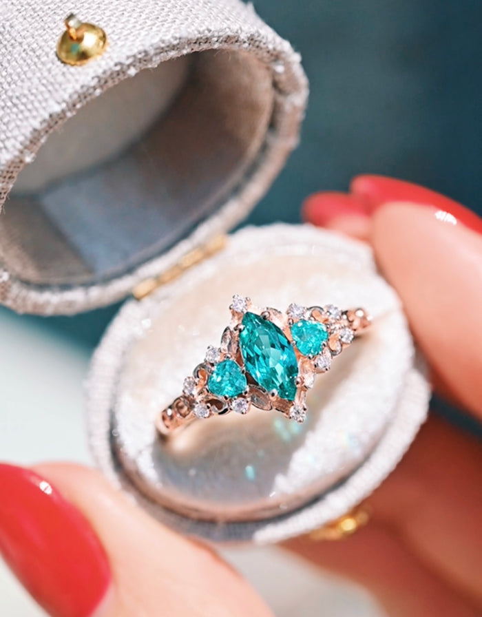 Elain Teal Sapphire Fairy Engagement Ring in 14K Rose Gold Vermeil with marquise and round teal sapphires surrounded by sparkling stones in an elegant box by Aquamarise.
