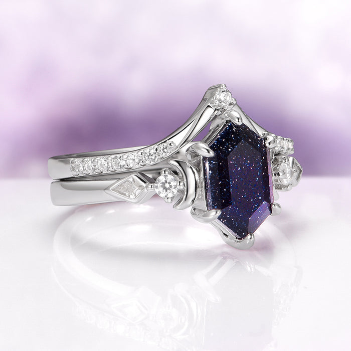Elara Starry Night and Crescent Moon Couples Ring Set features a hexagonal deep blue gemstone with sparkling flecks, set in polished sterling silver accented by crescent moon and diamond-like stones, crafted by Aquamarise.