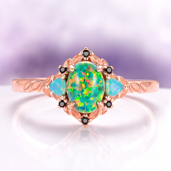 Green Fire Opal Leaf Engagement Ring in 14K Rose Gold Vermeil featuring a vibrant green fire opal center, opalescent side stones, and intricate leaf engraving by Aquamarise.