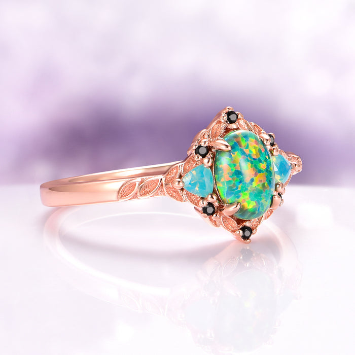 Green Fire Opal Leaf Engagement Ring in 14K Rose Gold Vermeil by Aquamarise featuring an opalescent green fire opal center with black gemstone accents and delicate leaf engravings.
