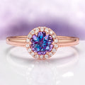 Ella Alexandrite Engagement Ring in 14K Solid Rose Gold by Aquamarise Gold features a dazzling round alexandrite center stone surrounded by a halo of sparkling diamonds on a finely detailed rose gold band, part of Solid Gold Engagement Rings and June Birthstone Jewelry collections.