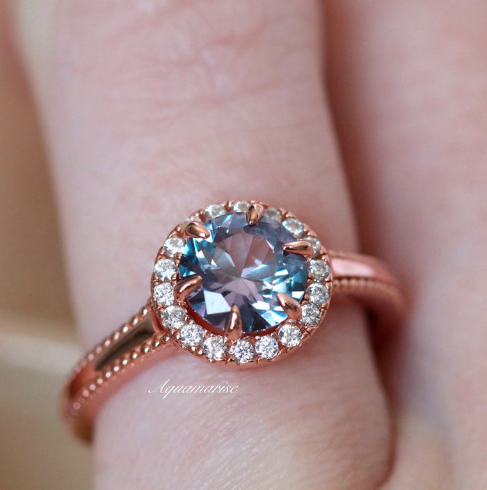 Ella Alexandrite Engagement Ring in 14K Solid Rose Gold by Aquamarise Gold features a radiant round alexandrite center stone framed by a halo of sparkling diamonds on an intricately detailed rose gold band, part of Solid Gold Engagement Rings and June Birthstone Jewelry collections.