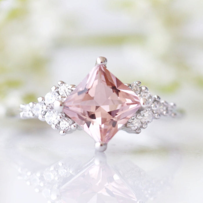 Ellie Princess Cut Morganite Engagement Ring in Sterling Silver by Aquamarise featuring a blush pink princess-cut morganite with shimmering simulated diamond accents in a romantic setting.