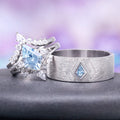 Two silver rings with blue gemstones on a gray surface with a blurred purple background
