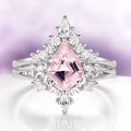 Ring with pink gemstone and diamond accents on a light purple background