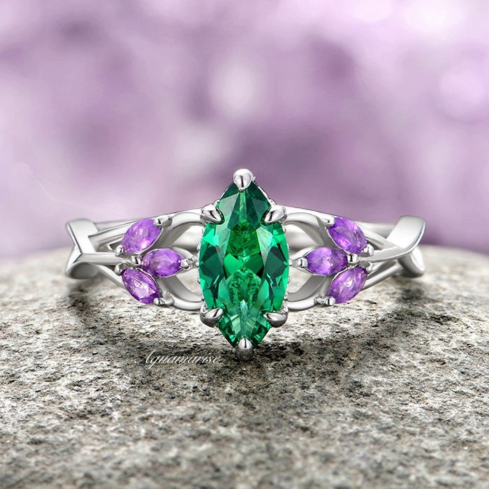 Emerald & Amethyst Mystical Fairy Ring- 14K White Gold featuring a marquise emerald centerpiece flanked by six small marquise amethysts, set on a delicate white gold band with nature-inspired twisting vines, crafted by Aquamarise Gold for unique and fantasy-inspired engagement and promise rings.
