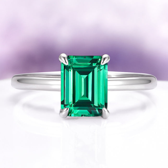 Emerald Engagement Ring in 14K White Gold (Hidden Halo) by Aquamarise Gold, featuring a vibrant emerald-cut emerald on a sleek white gold band.
