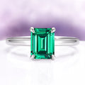 Emerald Engagement Ring in 14K White Gold (Hidden Halo) by Aquamarise Gold, featuring a vibrant emerald-cut emerald on a sleek white gold band.