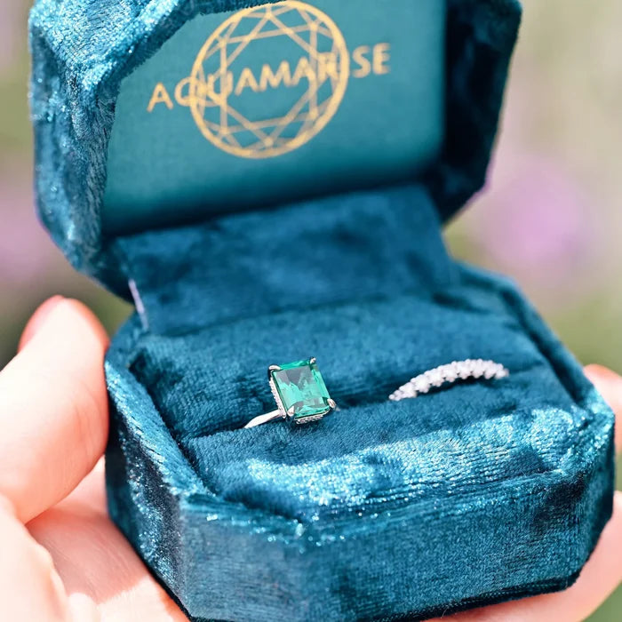 Emerald Engagement Ring in 14K White Gold (Hidden Halo) by Aquamarise Gold, featuring a radiant emerald-cut emerald on a white gold band in a luxurious teal velvet box.