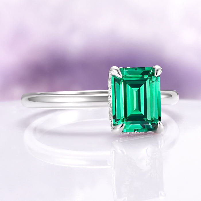 Emerald Engagement Ring in 14K White Gold (Hidden Halo) by Aquamarise Gold, featuring a striking emerald-cut lab-grown emerald on a polished white gold band with subtle diamond accents.