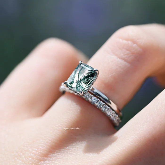 Moss Agate Engagement Ring in 14K White Gold (Hidden Halo) by Aquamarise Gold, featuring an emerald-cut green moss agate with a delicate white gold band and diamond accents.