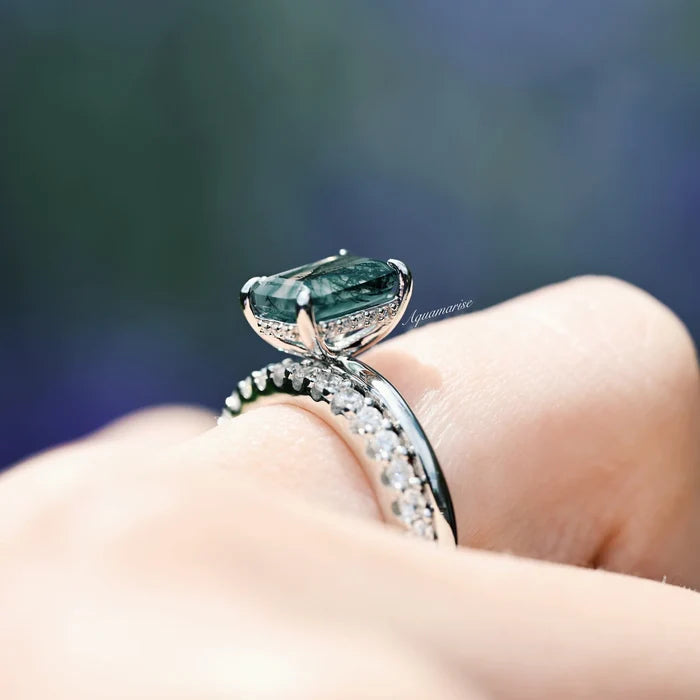Moss Agate Engagement Ring in 14K White Gold (Hidden Halo) by Aquamarise Gold, featuring an emerald-cut green moss agate with diamond accents on a white gold band worn on a finger.