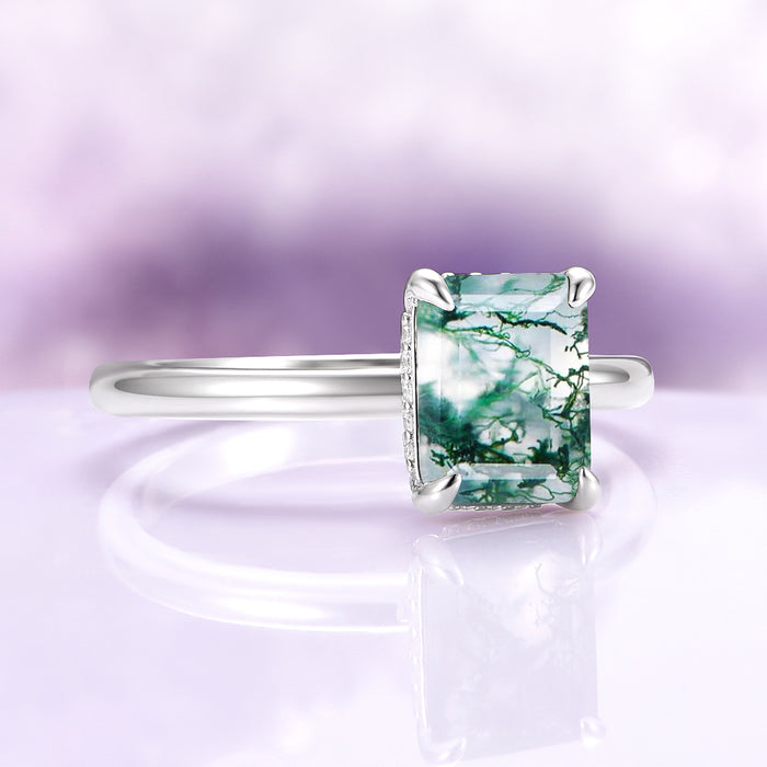 Moss Agate Engagement Ring in 14K White Gold (Hidden Halo) by Aquamarise Gold, featuring an emerald-cut green moss agate with a delicate white gold band and subtle diamond accents.