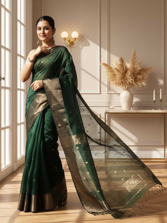 Dark emerald green Maheshwari silk saree with a semi-sheer body, small gold buti and metallic gold borders, handwoven in Maheshwar