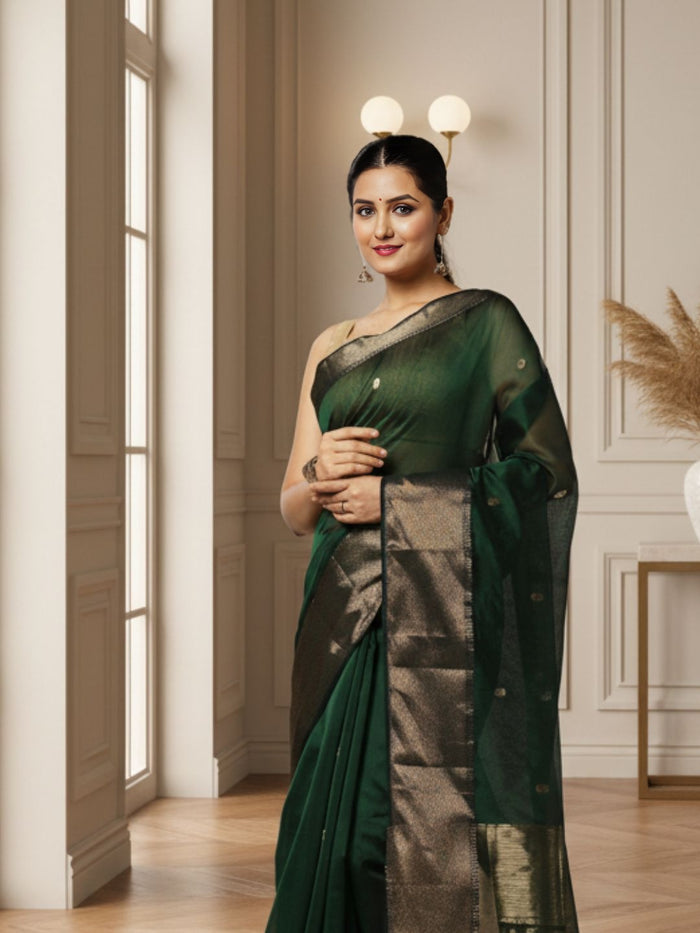 Dark emerald green Maheshwari silk saree with a semi-sheer body, small gold buti and metallic gold borders, handwoven in Maheshwar