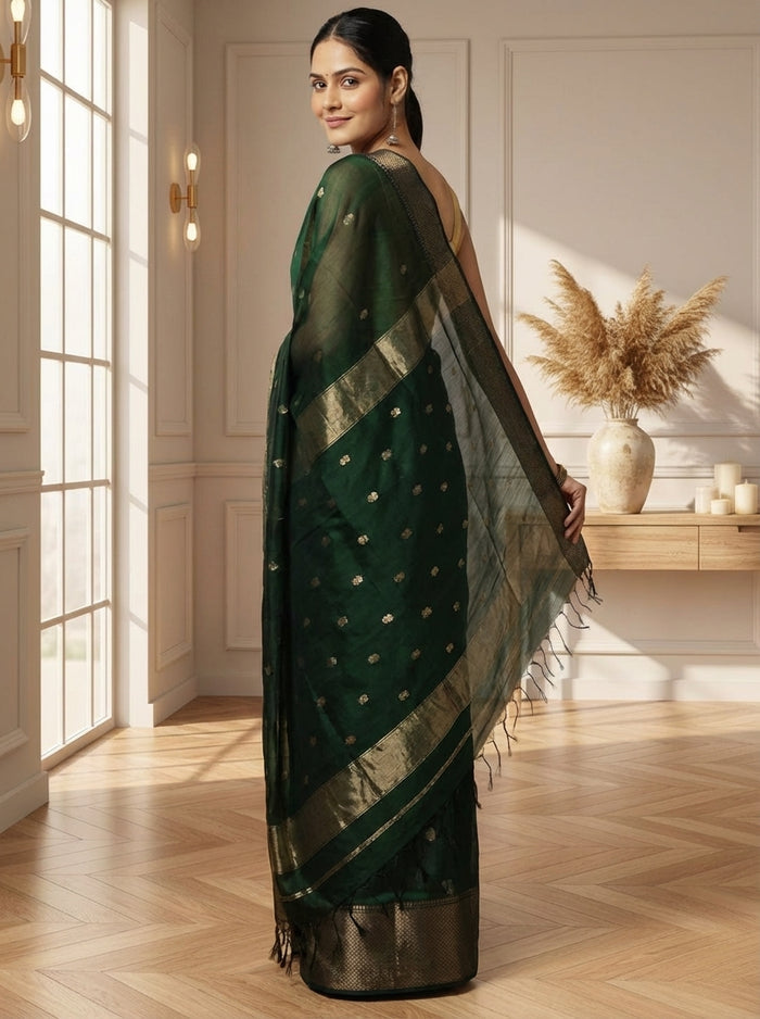 Dark emerald green Maheshwari silk saree with a semi-sheer body, small gold buti and metallic gold borders, handwoven in Maheshwar
