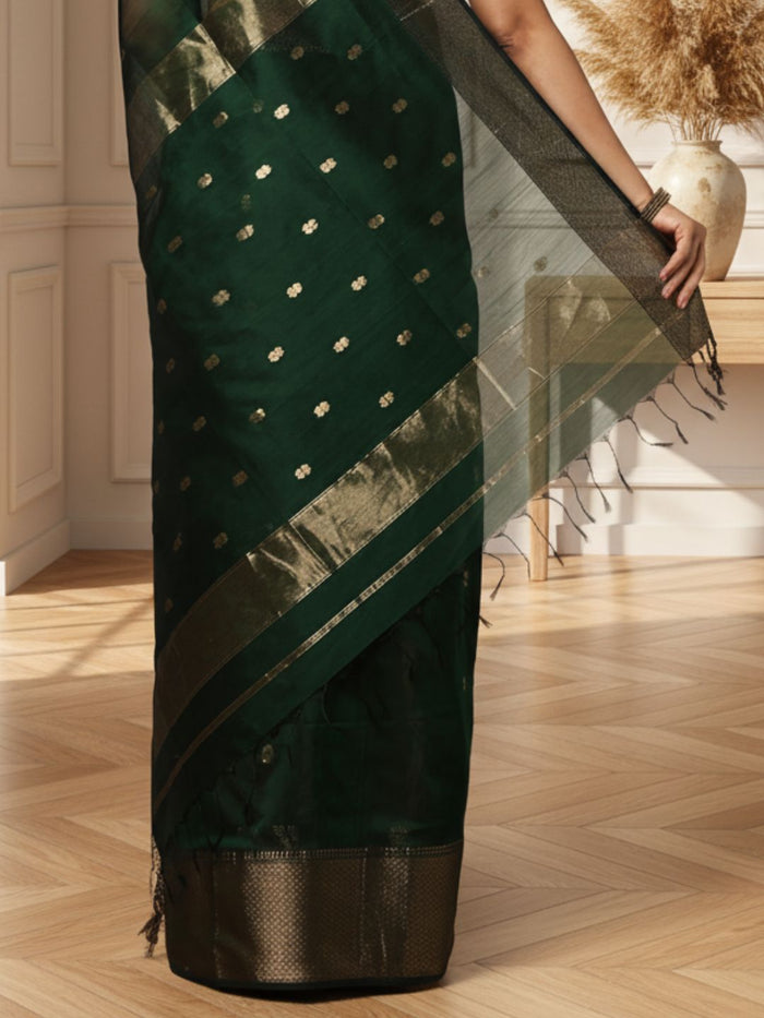 Dark emerald green Maheshwari silk saree with a semi-sheer body, small gold buti and metallic gold borders, handwoven in Maheshwar