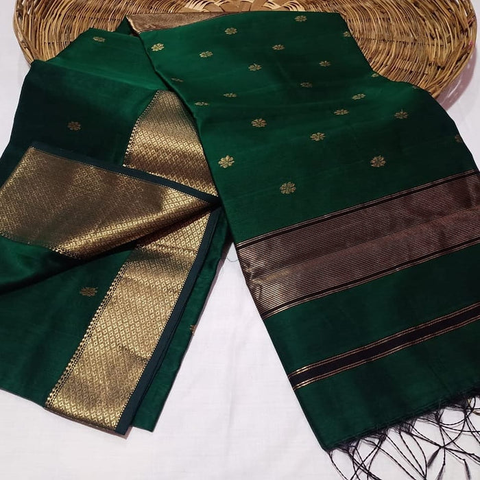 Dark emerald green Maheshwari silk saree with a semi-sheer body, small gold buti and metallic gold borders, handwoven in Maheshwar