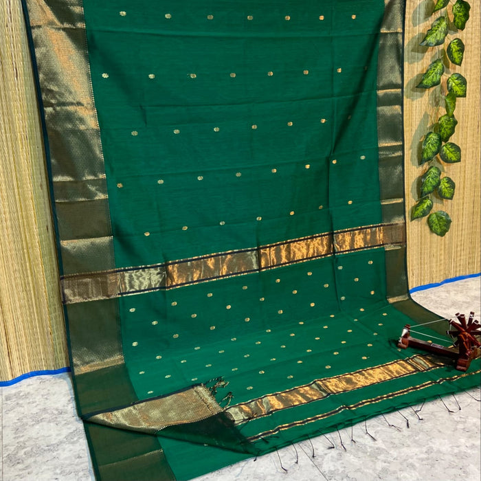 Dark emerald green Maheshwari silk saree with a semi-sheer body, small gold buti and metallic gold borders, handwoven in Maheshwar