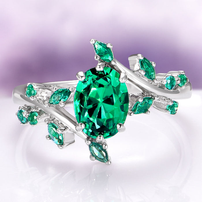 Oval Cut Lab-Grown Emerald Leaf Engagement Ring in 14K White Gold by Aquamarise Gold, featuring a vivid oval emerald and leaf-inspired accents from the Nature-Inspired Engagement Rings collection.