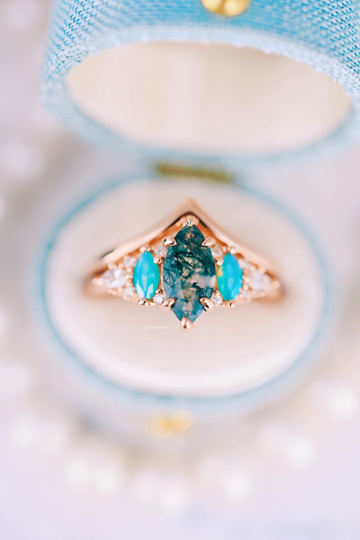 Emerie Moss Agate & Opalescent Sapphire Engagement Ring Set in 14K Solid Rose Gold featuring a marquise moss agate center stone accented by bright opalescent sapphires and delicate diamond details, crafted by Aquamarise Gold.