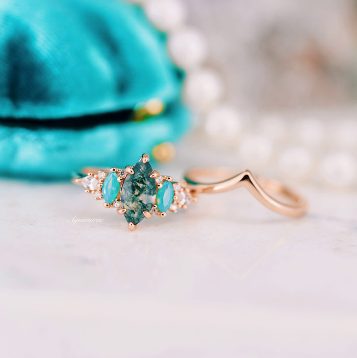 Emerie Moss Agate & Opalescent Sapphire Engagement Ring Set in 14K Solid Rose Gold featuring a marquise moss agate center stone accented by oval opalescent sapphires and small diamonds, crafted by Aquamarise Gold.