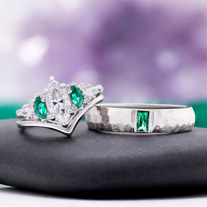 Emerie Diamond & Emerald Couple Ring by Aquamarise, the engagement ring and hammered emerald band shown on a grey stone pedestal.