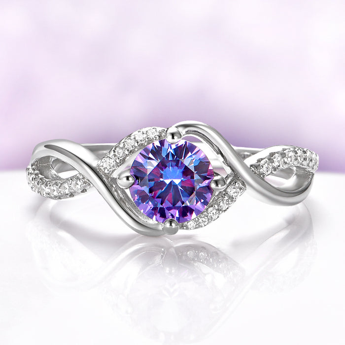 Entwined Alexandrite Ring in Sterling Silver by Aquamarise, featuring a round color-change stone with a twisting band accented by sparkling pavé crystals in a modern, elegant design.