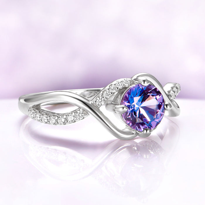 Entwined Alexandrite Ring in Sterling Silver by Aquamarise, featuring a round color-shifting alexandrite center with a twisted pavé-accented band in a unique, elegant design.