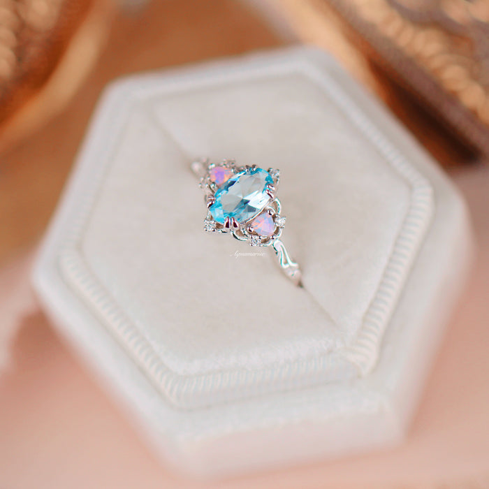 Esme Aquamarine & Opalescent Sapphire Ring in 14K White Gold with oval aquamarine center and delicate sapphire accents on an elegant white gold band by Aquamarise Gold.