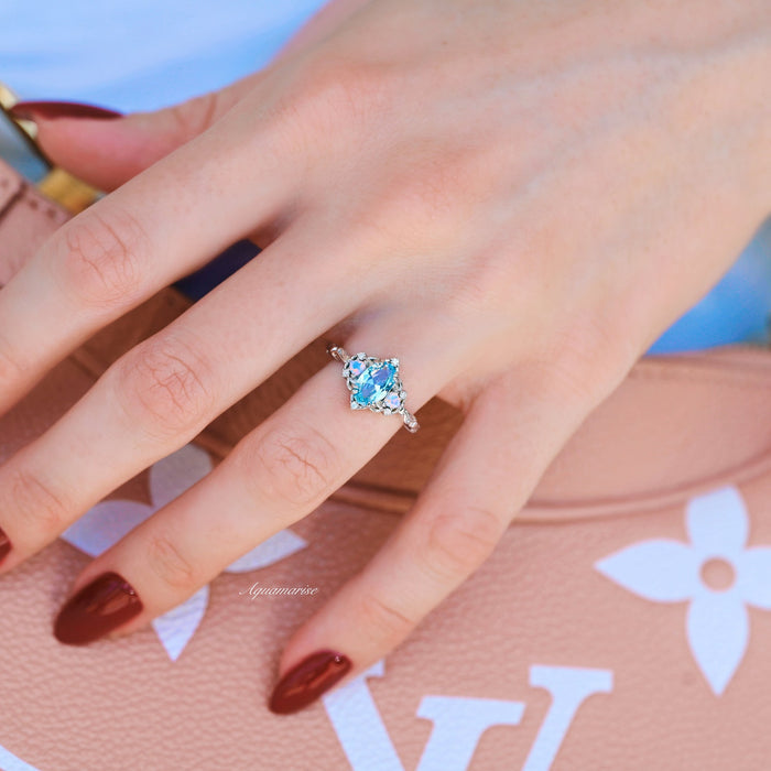 Esme Aquamarine & Opalescent Sapphire Ring in 14K White Gold featuring light blue aquamarine with delicate sapphire accents on a white gold band by Aquamarise Gold.
