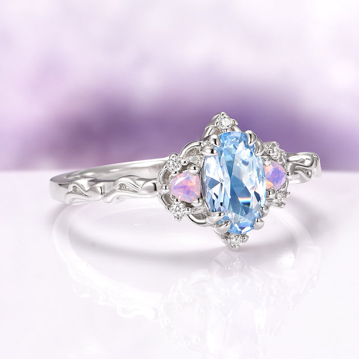 Esme Aquamarine & Opalescent Sapphire Ring in 14K White Gold featuring an oval aquamarine center with delicate opalescent sapphires and diamond accents on a sculpted white gold band.
