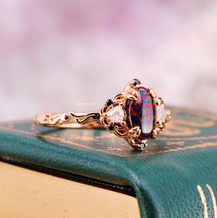 Esme Black Fire Opal Ring- 14K Rose Gold Vermeil featuring an oval black fire opal with red flashes and black gemstone accents in an intricate rose gold setting by Aquamarise.