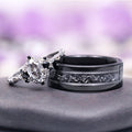 Esme Gray Moissanite and Meteorite Couples Ring Set featuring a marquise-cut moissanite with black accents on a textured silver band paired with a wide black tungsten carbide ring inlaid with meteorite, by Aquamarise.