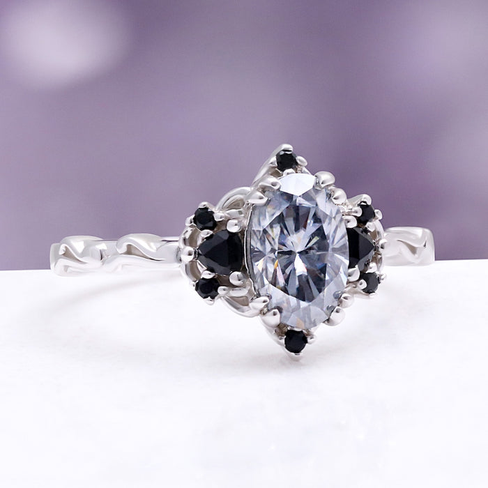 Esme Gray Moissanite Ring by Aquamarise, angled view showing the oval grey moissanite between black onyx side stones.