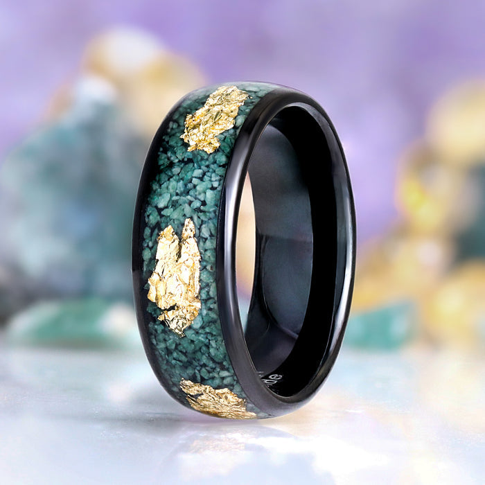 Green moss agate and gold leaf men's ring by Aquamarise displayed on a ring stand, showing the black band with gold leaf inlay