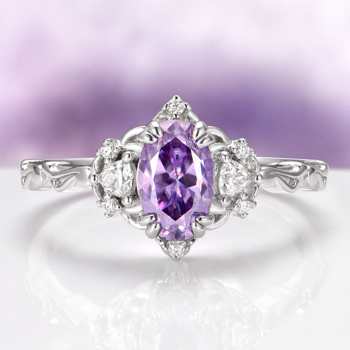 Esme Lavender Moissanite Ring Engagement Ring in 14K White Gold by Aquamarise Gold showcasing a vibrant oval lavender moissanite center stone flanked by sparkling colorless moissanite accents and an intricate nature-inspired band design from the Solid Gold Moissanite Engagement Rings collection.