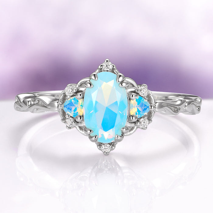 Esme Opalescent Blue Sapphire Mermaid Ring in 925 Sterling Silver featuring a marquise blue sapphire with opalescent side stones and diamond accents on an intricately detailed silver band.
