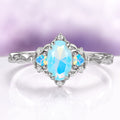 Esme Opalescent Blue Sapphire Mermaid Ring in 925 Sterling Silver featuring a marquise blue sapphire with opalescent side stones and diamond accents on an intricately detailed silver band.