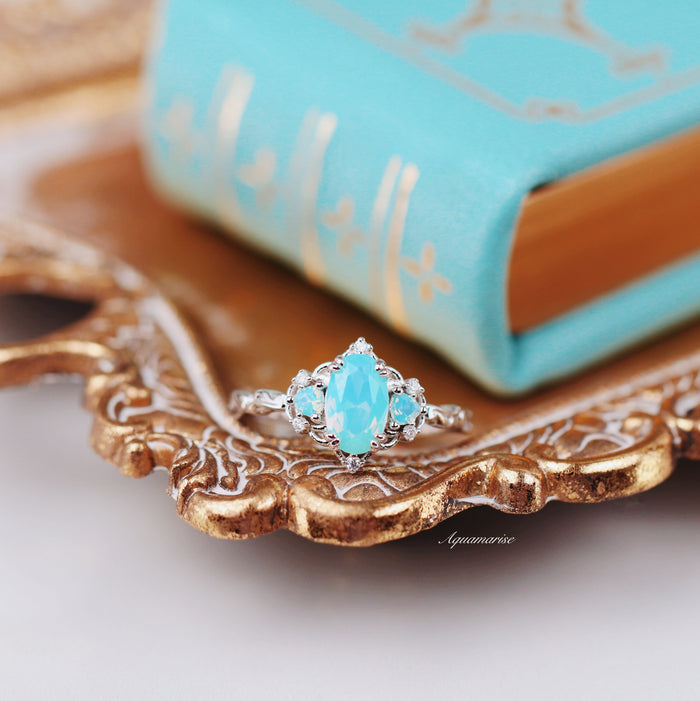 Esme Opalescent Blue Sapphire Mermaid Ring in 925 Sterling Silver with marquise blue sapphire and intricate detailing, displayed on an ornate gold tray by Aquamarise.