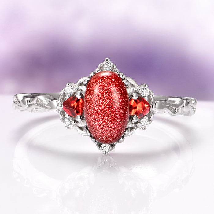Esme Red Goldstone & Orange Sapphire Ring in Sterling Silver by Aquamarise featuring a sparkling red goldstone cabochon with vibrant orange sapphires and delicate silver detailing in a vintage-inspired design.