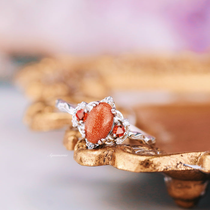 Esme Red Goldstone & Orange Sapphire Ring in Sterling Silver by Aquamarise featuring an oval red goldstone center with sparkling orange sapphires and intricate silver details.