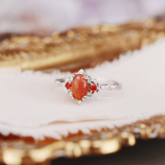 Esme Red Goldstone & Orange Sapphire Ring in Sterling Silver featuring a sparkling oval red goldstone center flanked by vibrant orange sapphires in an intricate silver setting by Aquamarise.