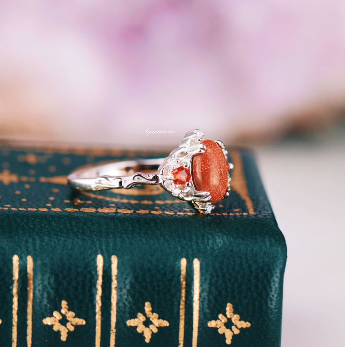 Esme Red Goldstone & Orange Sapphire Ring in Sterling Silver by Aquamarise featuring a vintage-inspired design with a sparkling red goldstone center and vibrant orange sapphires set in detailed silver.