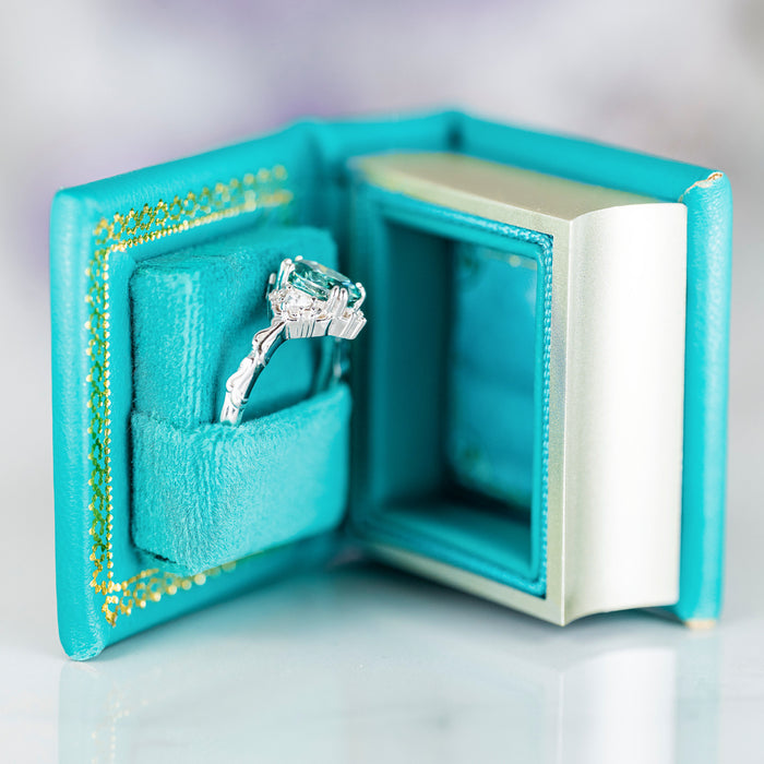 Summer Court Handmade Leather Book Ring Box- Ocean Tide Teal Edition (Small) displaying a silver engagement ring, crafted by Aquamarise for meaningful jewelry gifts and proposals.