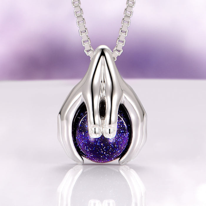 Ethereal Hold Starry Night Pendant Necklace in Sterling Silver by Aquamarise, featuring polished sterling silver sculpted hands gently cradling a luminous deep blue starry orb, part of Night Court Jewelry and Meaningful Gifts collections.