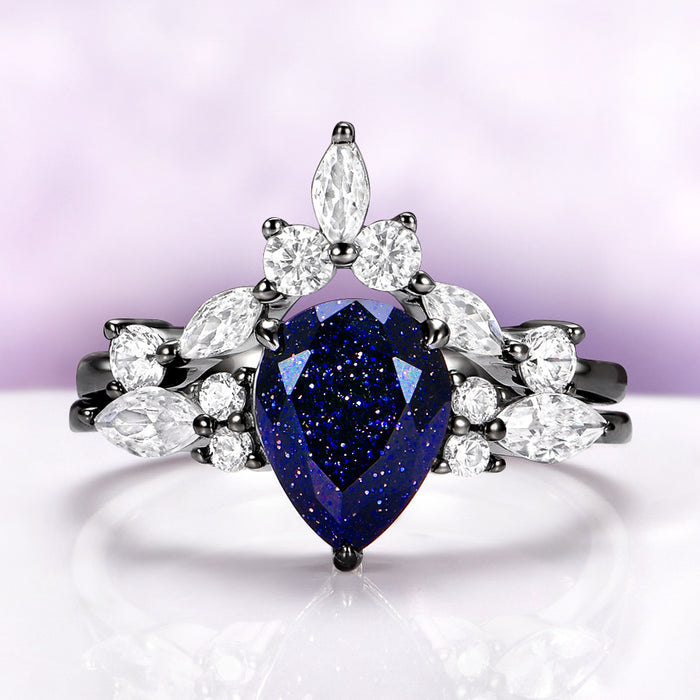 Evelyn Starry Night Ring Set in Black Ruthenium by Aquamarise featuring a pear-cut blue sandstone with marquise and round white stones in 925 sterling silver with black ruthenium finish.